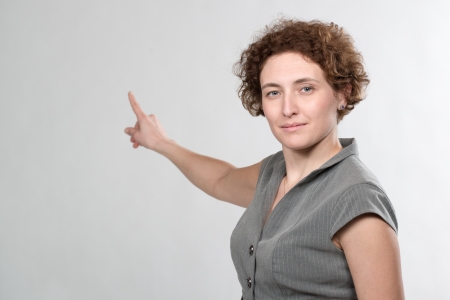 curly business woman pointing with finger on white backgroundの写真素材