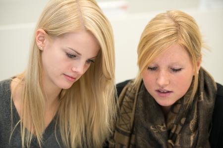 two female students learning, looking downの写真素材