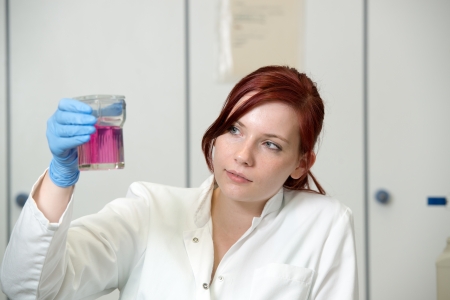 young female scientist works in laboratory wearing white coatの写真素材