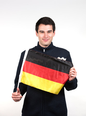 young man  wearing winter clothes, holding german flagの写真素材