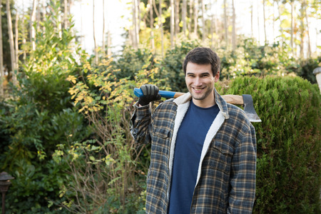 young man  working in garden with axeの写真素材