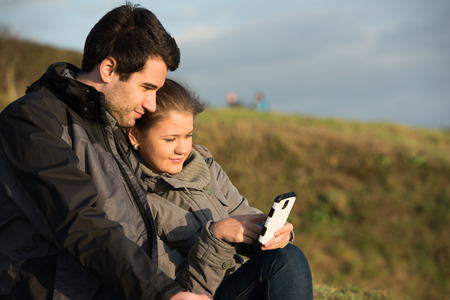 young couple, man and woman using smart phoneの写真素材
