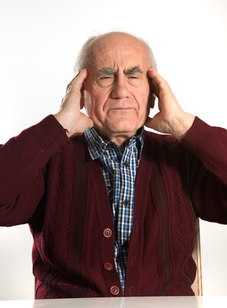 old senior man having problems, thinking, beeing serious, having headacheの写真素材