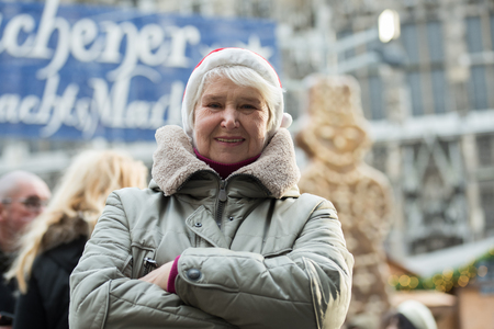 Elderly woman wearing red hat at Chrismas market in Aachen, Germanyの写真素材
