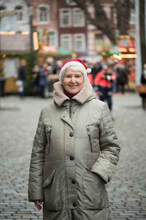 Elderly woman wearing red hat at Chrismas market in Aachen, Germanyの写真素材