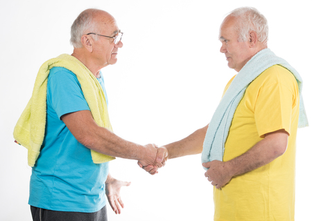 two happy smiling senior men after sport training with yellow and blue t-shirts and towelsの写真素材