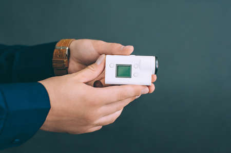 White action video camera, in the hands of a guy on a black background in the studioの写真素材