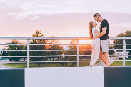 The guy and the girl are kissing in the setting sunの写真素材