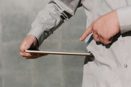 Close-up, Finger in front of tablet screen, in hand, Business man. against the background of a...