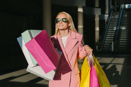 Happy woman with bags, enjoying your shopping. in the store against the background of the escolator. Consumer protection, lifestyle concept.の写真素材