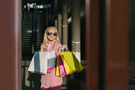 Happy woman with bags, enjoying your shopping. in the store against the background of the escolator. Consumer protection, lifestyle conceptの写真素材