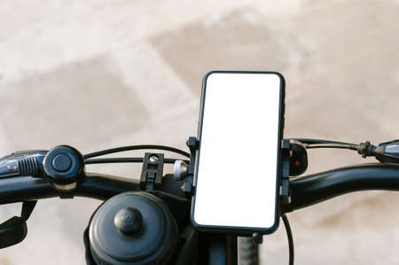 Close-up, mockup of a smartphone on the handlebars of a bicycle. Against the background of concrete...