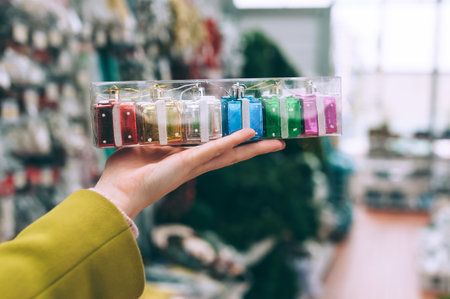 The girl in the store holds in her hand New Year's decorative gifts ornaments on the treeの写真素材