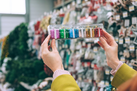 The girl in the store holds in her hands New Year's decorative gifts ornaments on the treeの写真素材