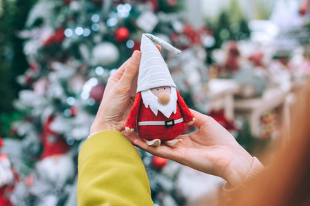 The girl is holding Santa Claus - the gnome in her hands. Against the background of a Christmas New...