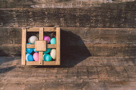 Painted eggs in a box. On the table against the background of an old board