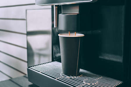 Preparing coffee in a takeaway glass in a coffee machineの写真素材