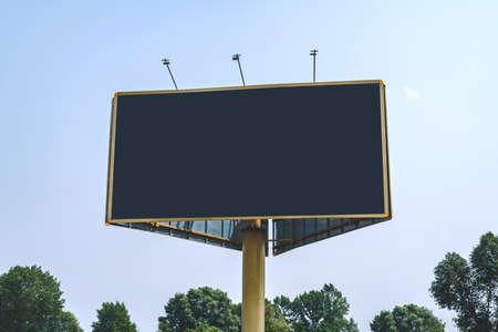 Blank billboard mockup with white screen. Against the backdrop of nature and blue sky. business...