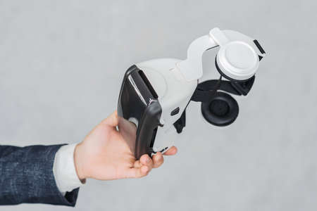 Virtual reality glasses, close-up in a man's hand. On a light backgroundの写真素材