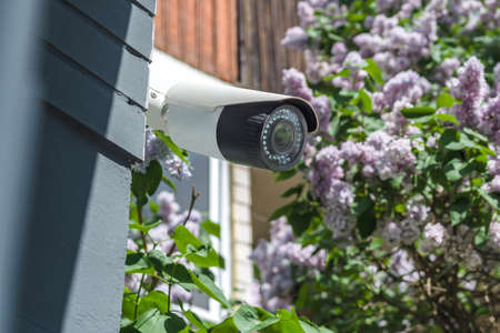 Surveillance camera, on the house and jasmine bushの写真素材