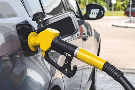 The gas station gun is inserted into the gas tank for refueling. close-up viewの写真素材
