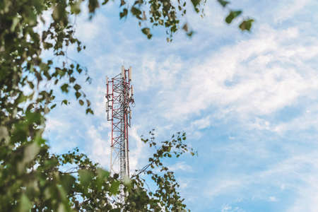 Cell tower against a blue sky with cloudsの写真素材