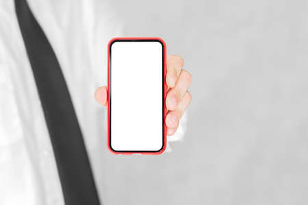 Close-up, red smartphone mockup in business man's hand. On a light backgroundの写真素材