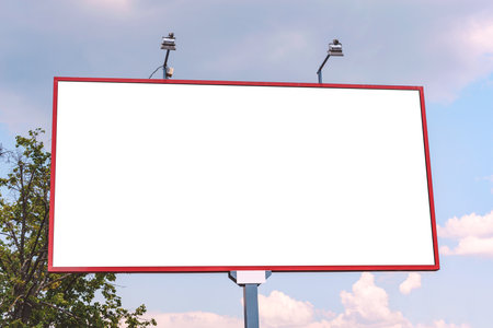 Blank billboard mockup. against the background of a tree and a sky with cloudsの写真素材