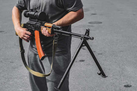 Armed man with a sniper machine gun military weapon in the hands of a man