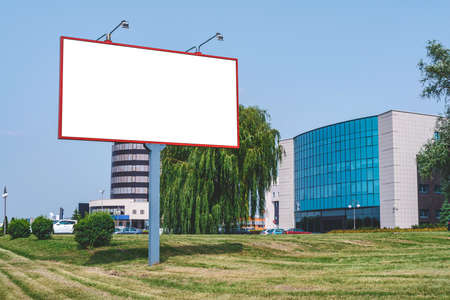 Mockup, Billboard. Against the backdrop of the business center of the city with green grassの写真素材
