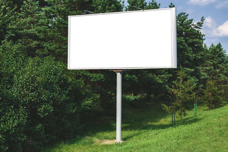 Blank billboard mockup with white screen. Against the backdrop of nature and blue sky. business concept. Copy space banner for advertisingの写真素材