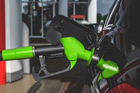 Close-up, Green pistol gas station is inserted into the tank for refuelingの写真素材