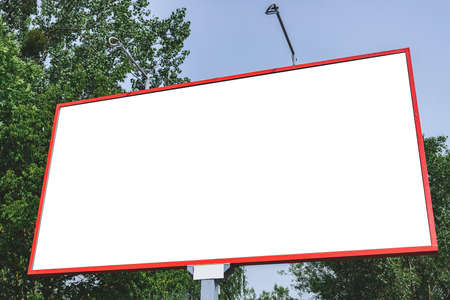 Blank billboard mockup with white screen. Against the backdrop of nature and blue sky. business...