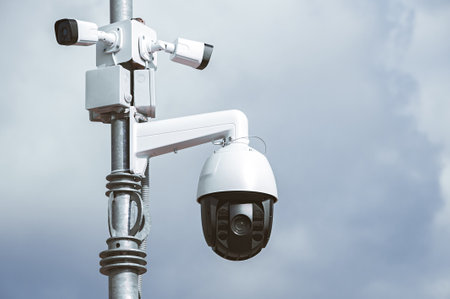 Surveillance camera on a street lamp. Against the background of the sky. AI people tracking technology concept CCTV security systemの写真素材