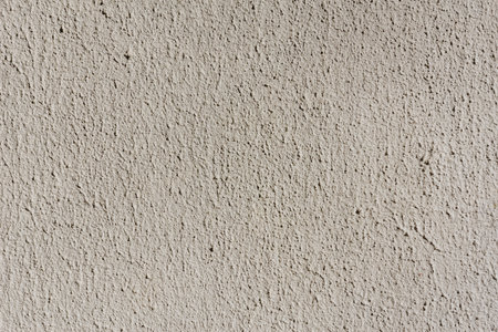 Close-up, background texture of a beige facade wall of a house made of decorative plaster. Abstract surfaceの写真素材