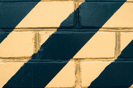 Close-up of the background texture of yellow and black stripes indicating columns, corners and danger zones on the wallsの写真素材