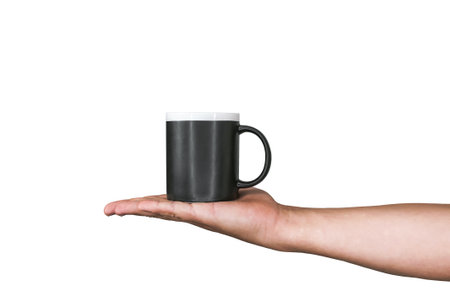 Isolated black mug for coffee, tea in a man's hand. On a white backgroundの写真素材