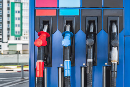 Close-up of a blue fuel dispenser with fuel pistols at a gas station. Background of apartment buildings.の写真素材