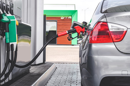 A car at a gas station. Against the background of a column with fuel hoses of diesel, eco hydrogenの写真素材