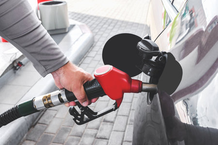Close-up of a man filling up a car at a gas stationの写真素材