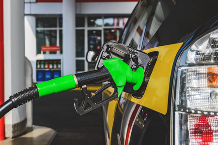 Refueling a car with fuel at a gas station with a green gun. Close-upの写真素材