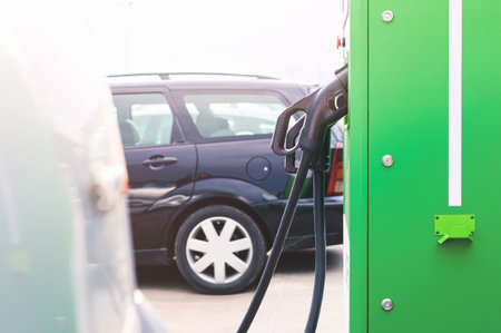 Close-up Green electric station for charging vehicles. Parking background with cars outdoorsの写真素材