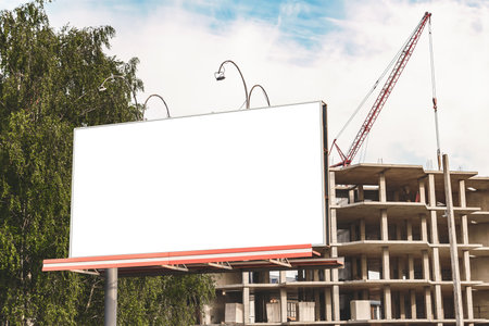 Horizontal billboard mockup on the background of a construction site with a craneの写真素材