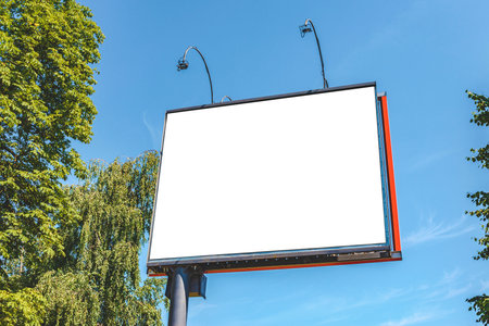 Mock-up of a street square billboard against the background of the sky and treesの写真素材
