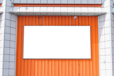 Blank banner or billboard mockup on orange building wall. Street advertising on the screen of the cityの写真素材