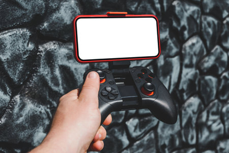 Close-up mockup of a smartphone with a copter remote control in a man's hand. Background folded gray stone wallの写真素材