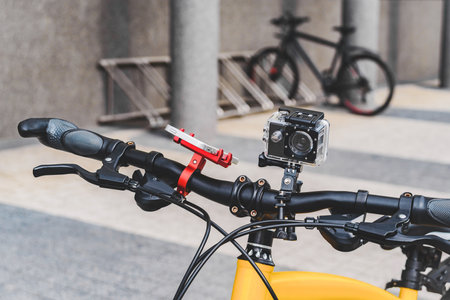 Close -up action camera on a bicycle steering wheel standing in the city in the street. The background of the facade of the building and the parked cyclingの写真素材