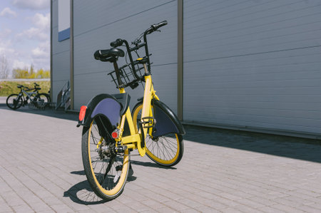A modern bicycle is parked on the sidewalk on a city street near a gray buildingの写真素材
