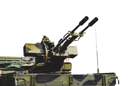 Isolate. Close-up of an anti-aircraft installation of a double-barreled machine gun. Military artillery vehicle with camouflage paint. White background.の写真素材