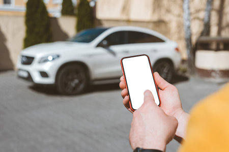 Mockup of a smartphone in a man's hand on the background of the carの写真素材